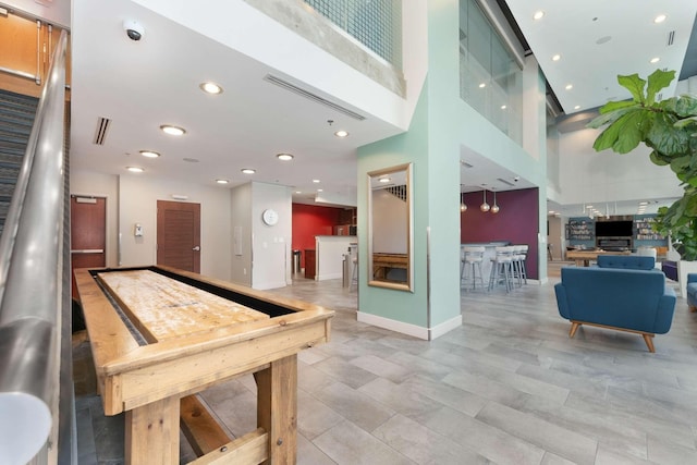 game room featuring a towering ceiling