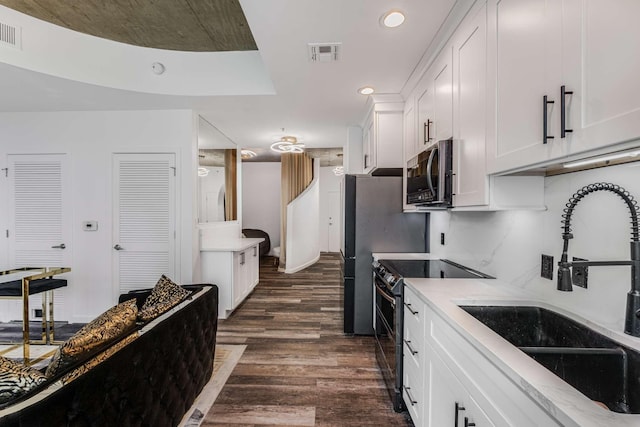 kitchen featuring white cabinetry, stainless steel appliances, dark hardwood / wood-style flooring, and sink