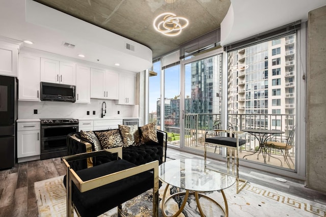 living room with sink, a wall of windows, and dark hardwood / wood-style floors