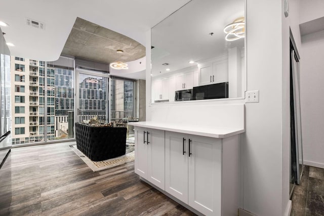 kitchen with white cabinetry, dark hardwood / wood-style flooring, floor to ceiling windows, and refrigerator