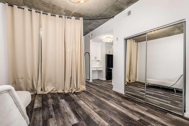 unfurnished bedroom featuring dark wood-type flooring and a closet