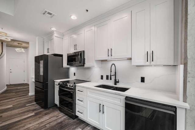 kitchen with dark wood-type flooring, appliances with stainless steel finishes, sink, and white cabinets