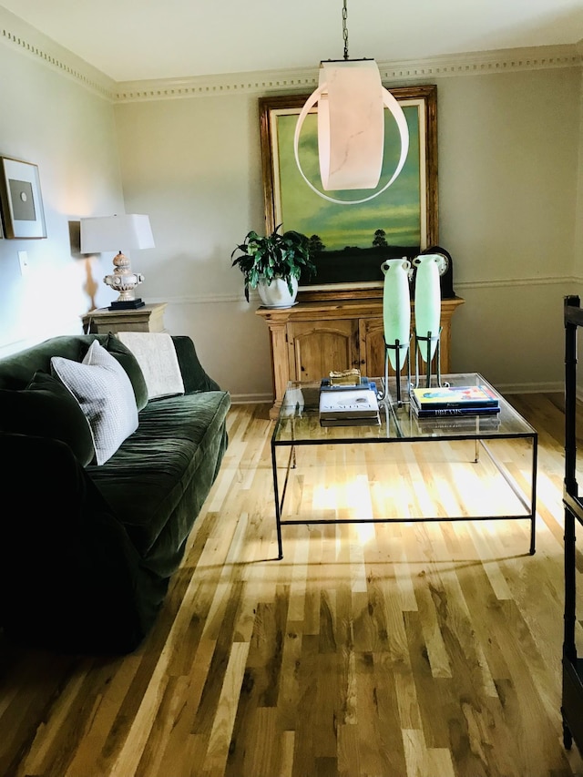 sitting room with crown molding and light wood-type flooring