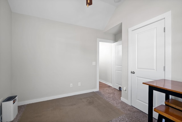 carpeted spare room with vaulted ceiling