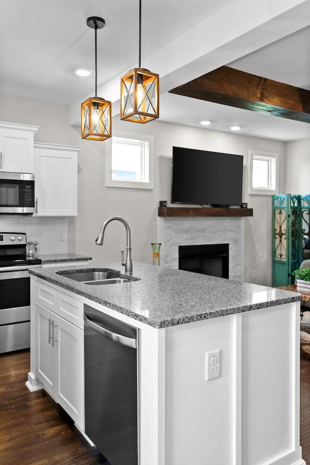 kitchen featuring white cabinetry, sink, hanging light fixtures, light stone counters, and stainless steel appliances