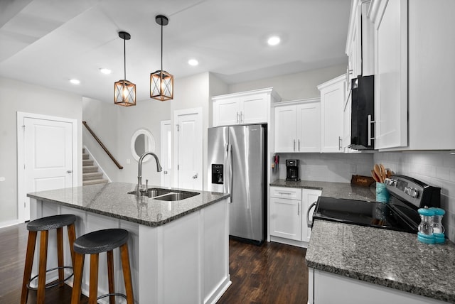 kitchen with a kitchen island with sink, range with electric stovetop, white cabinets, and stainless steel refrigerator with ice dispenser