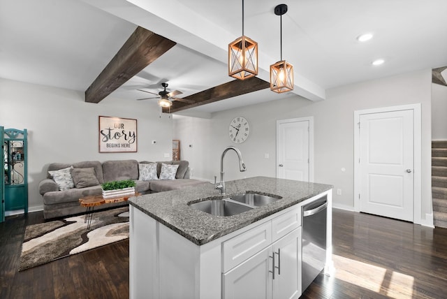 kitchen with pendant lighting, sink, white cabinets, dark stone counters, and stainless steel dishwasher