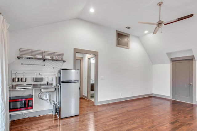 kitchen featuring lofted ceiling, hardwood / wood-style flooring, stainless steel refrigerator, and ceiling fan