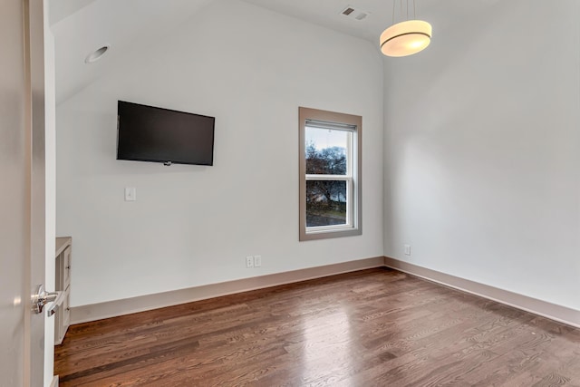 empty room with dark wood-type flooring and vaulted ceiling