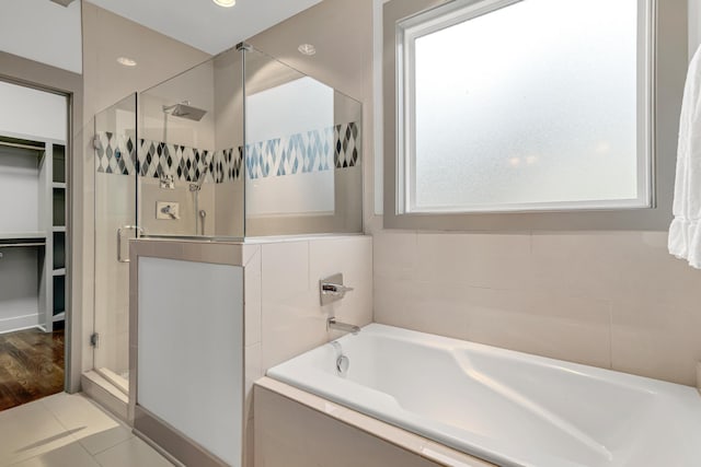 bathroom featuring tile patterned flooring and shower with separate bathtub