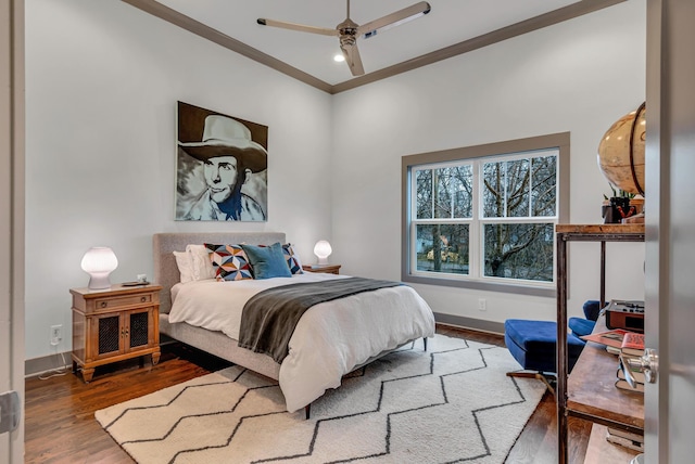 bedroom featuring hardwood / wood-style floors, ornamental molding, and ceiling fan