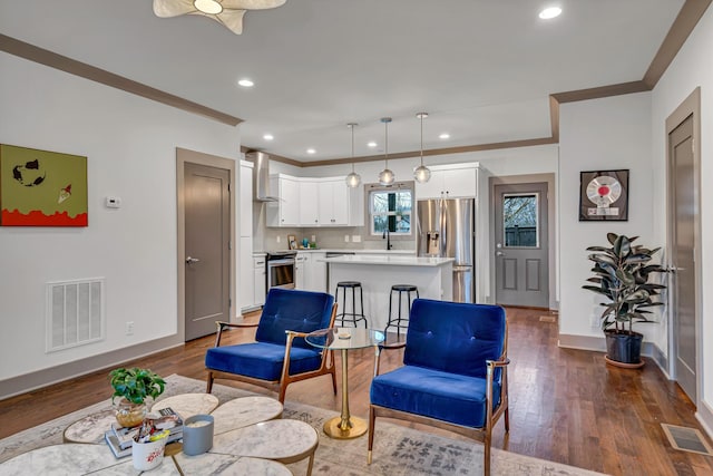 living room with ornamental molding, dark hardwood / wood-style flooring, and sink