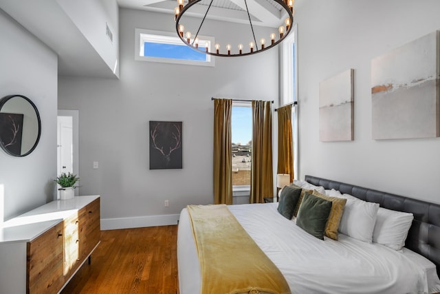 bedroom with dark wood-type flooring and a high ceiling