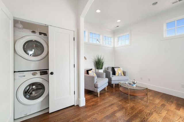 clothes washing area with stacked washer / drying machine and dark hardwood / wood-style floors