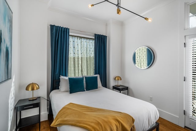 bedroom with ornamental molding and dark hardwood / wood-style flooring