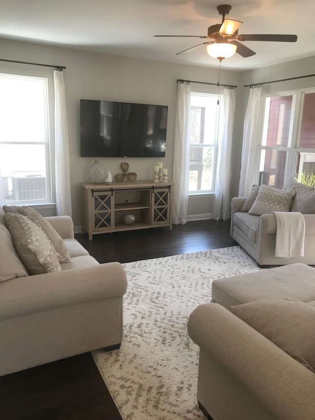 living room featuring a ceiling fan, baseboards, and wood finished floors