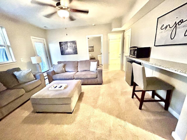 living area featuring ceiling fan and light carpet