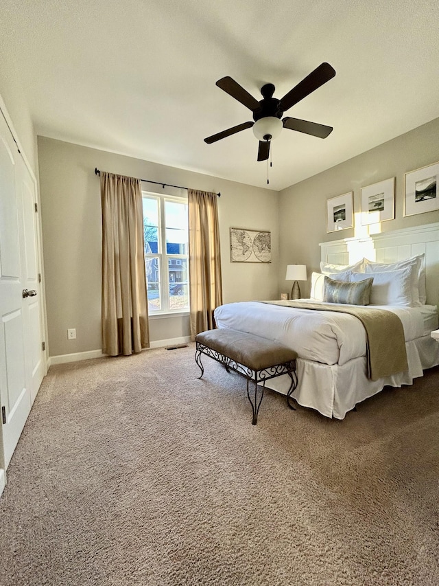 bedroom featuring carpet floors, baseboards, visible vents, and a ceiling fan