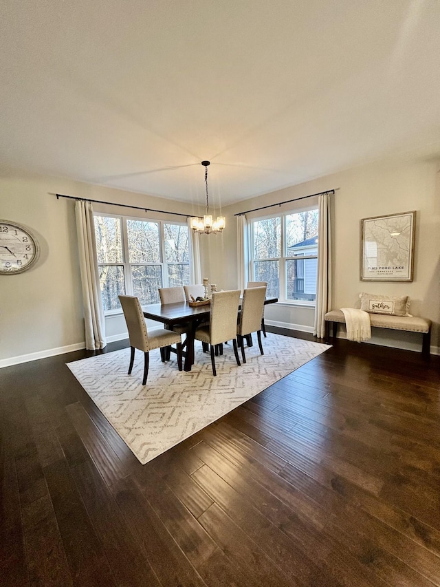 dining room with dark wood-style floors, baseboards, and an inviting chandelier