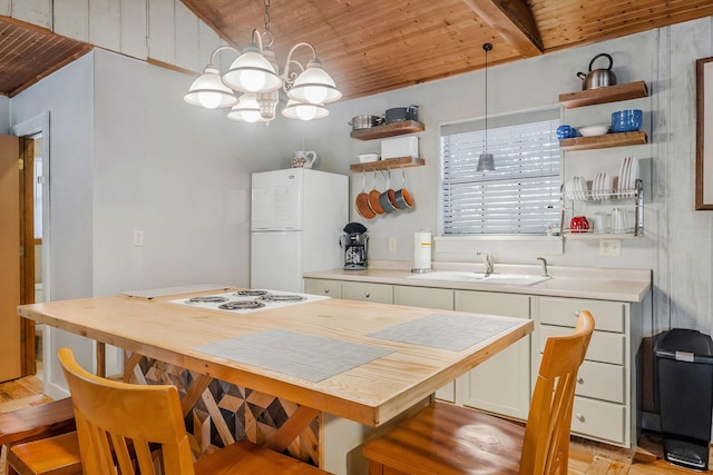 kitchen with pendant lighting, sink, wooden ceiling, and white fridge