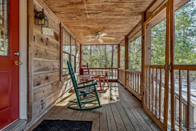 unfurnished sunroom with ceiling fan, wooden ceiling, and a healthy amount of sunlight