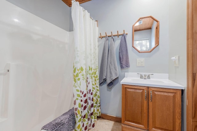 bathroom featuring walk in shower, vanity, and tile patterned flooring