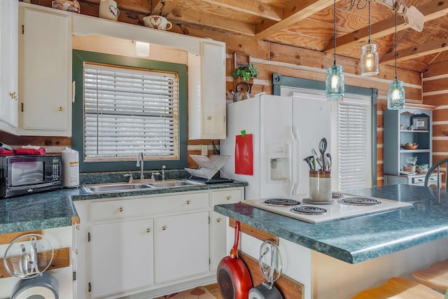 kitchen with white cabinetry, a breakfast bar area, sink, and hanging light fixtures