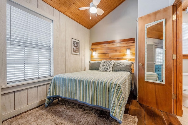 bedroom with lofted ceiling, wood walls, wood-type flooring, wooden ceiling, and ceiling fan