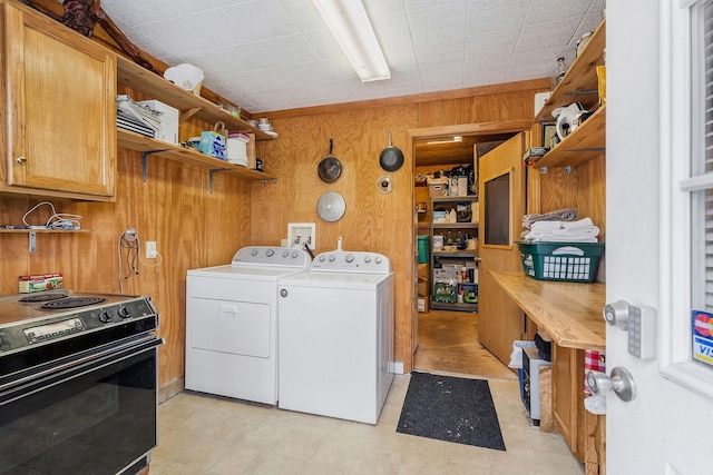 laundry room featuring wooden walls and washing machine and dryer