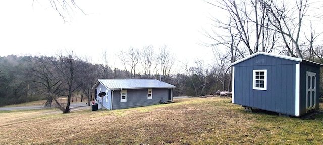 view of yard featuring central AC unit and a storage unit