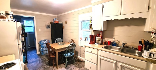 kitchen featuring white fridge, plenty of natural light, sink, and white cabinets