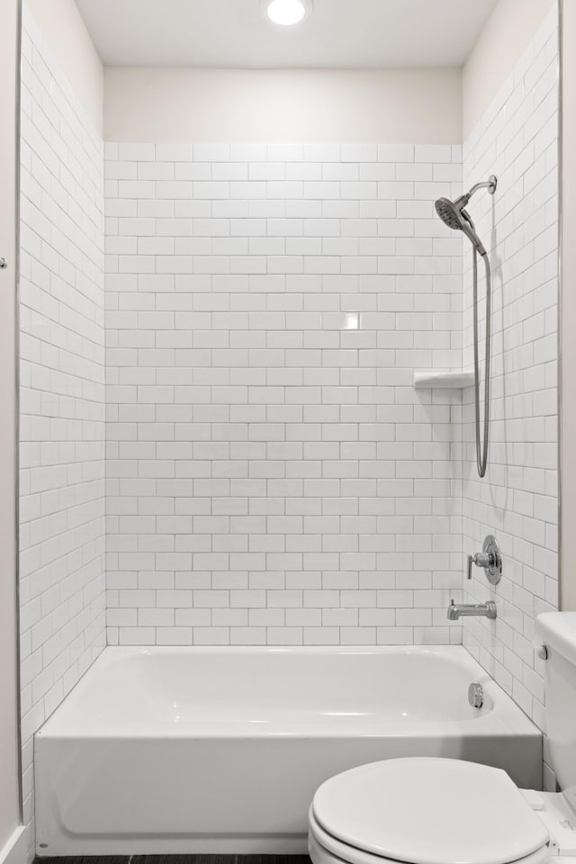 bathroom with tiled shower / bath and toilet