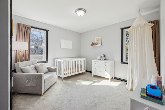 bedroom with a nursery area and carpet floors