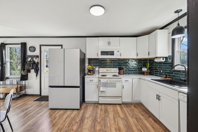 kitchen featuring white appliances, sink, and white cabinets