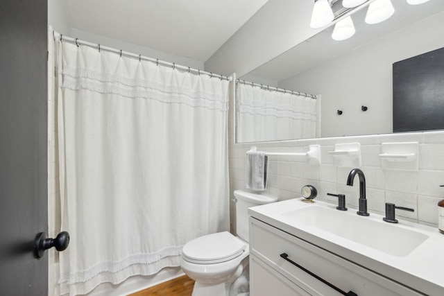 full bathroom with wood-type flooring, tile walls, vanity, toilet, and shower / bathtub combination with curtain