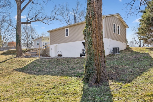 view of home's exterior with a yard and central AC