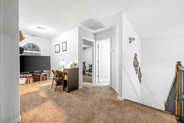 carpeted office space featuring a textured ceiling