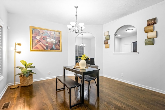 dining area with a notable chandelier and dark hardwood / wood-style floors