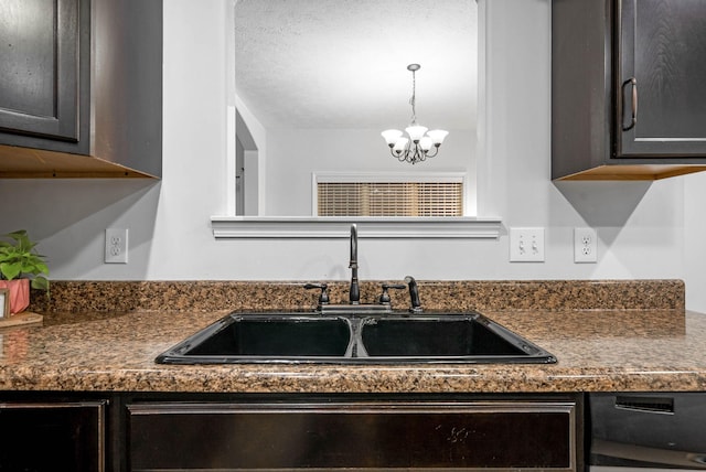 kitchen with decorative light fixtures, sink, dark brown cabinetry, a textured ceiling, and an inviting chandelier