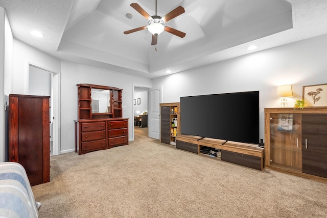 interior space featuring a raised ceiling and ceiling fan