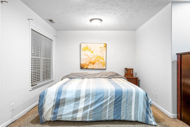 carpeted bedroom featuring a textured ceiling