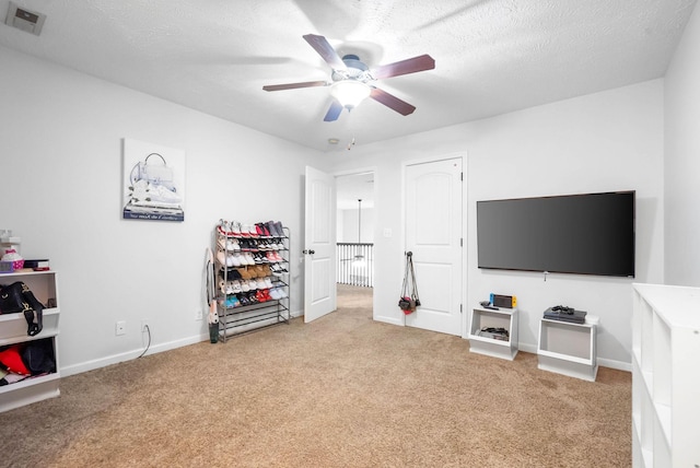 interior space with ceiling fan, carpet floors, and a textured ceiling