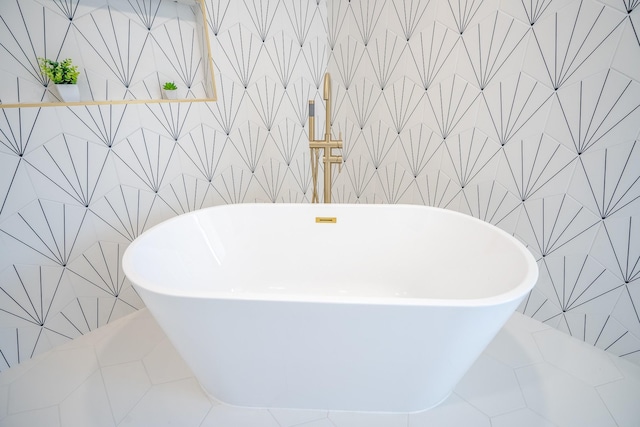 bathroom with a bathing tub, tile walls, and tile patterned floors