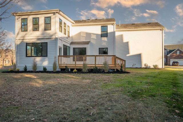 rear view of house featuring a wooden deck and a yard