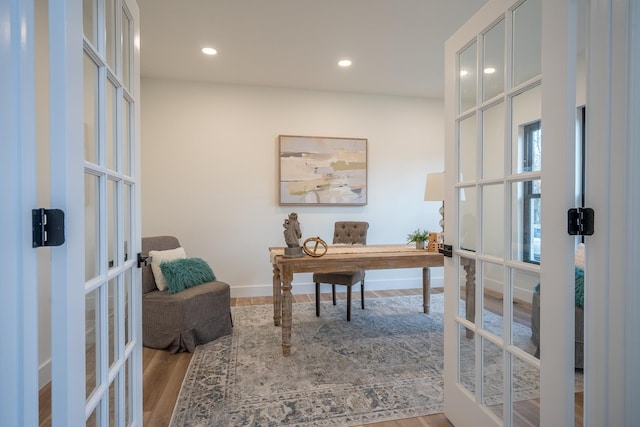 home office with french doors and light hardwood / wood-style floors