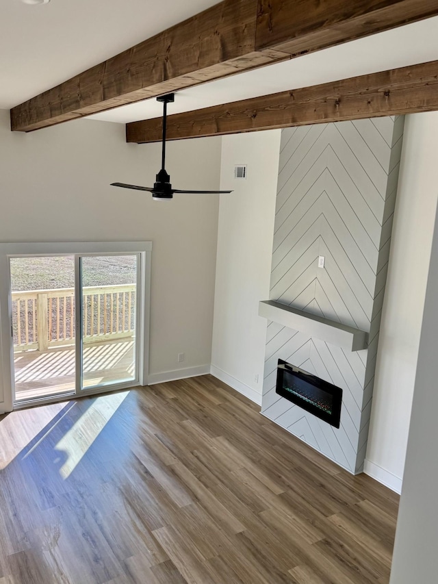 unfurnished living room with beam ceiling, wood-type flooring, ceiling fan, and a fireplace