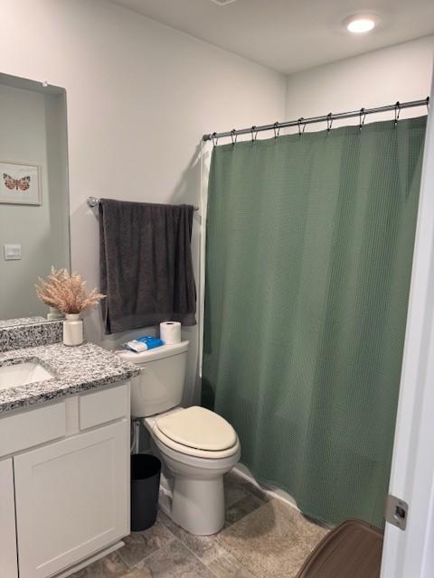 bathroom with a shower with curtain, vanity, and toilet