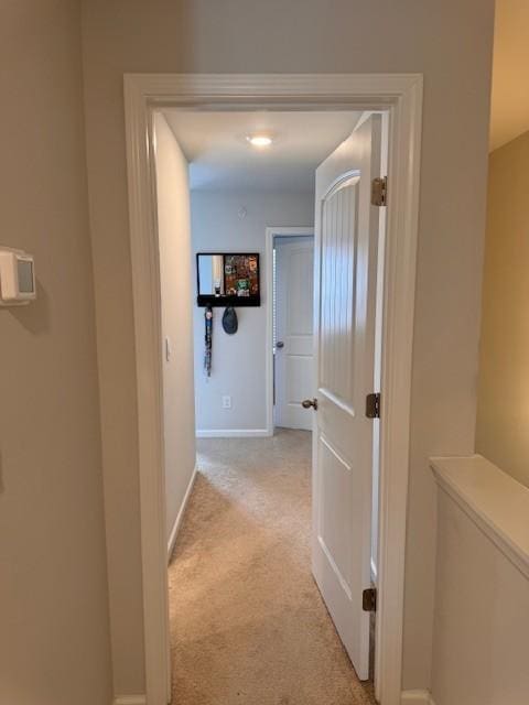 hallway featuring light colored carpet