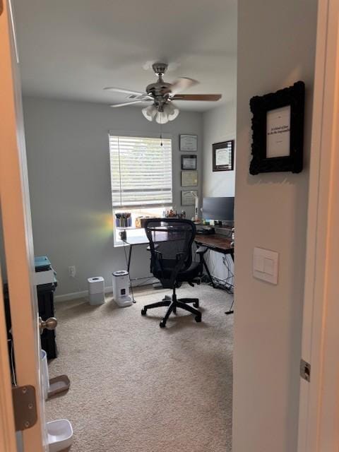 carpeted home office featuring ceiling fan