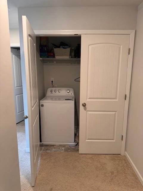 laundry area with washer / clothes dryer and light colored carpet